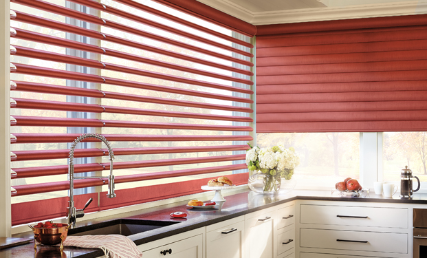 A modular L-shaped kitchen and the kitchen window are covered with red colour window bliinds